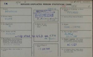 Archiwalny dokument rejestracyjny w języku angielskim zatytułowany „REFUGEE/DISPLACED PERSON STATISTICAL CARD”, dotyczący Piotra Nowocina, urodzonego 29 stycznia 1945 roku w Stutthofie. Karta ma jasny kolor, została wypełniona niebieskim pismem maszynowym oraz odręcznym i zawiera adnotację o emigracji do USA 15 lipca 1949 roku oraz fioletową pieczątkę IRO.